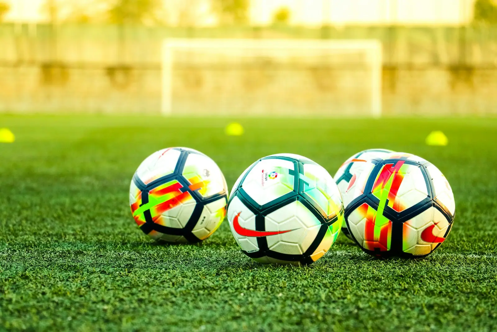 Drie voetballen in het gras